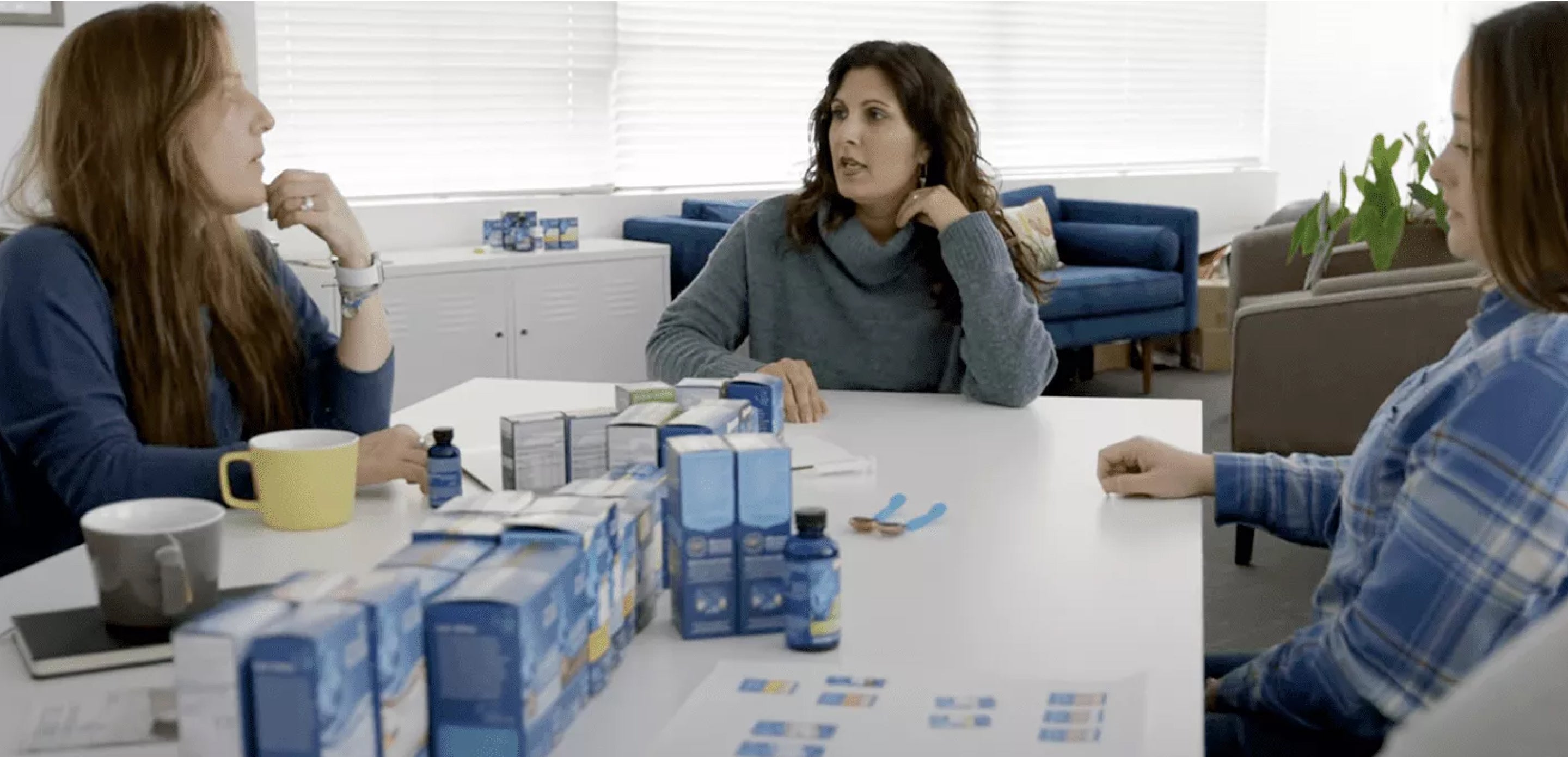 Three women discussing around the table with MB products on top of the table