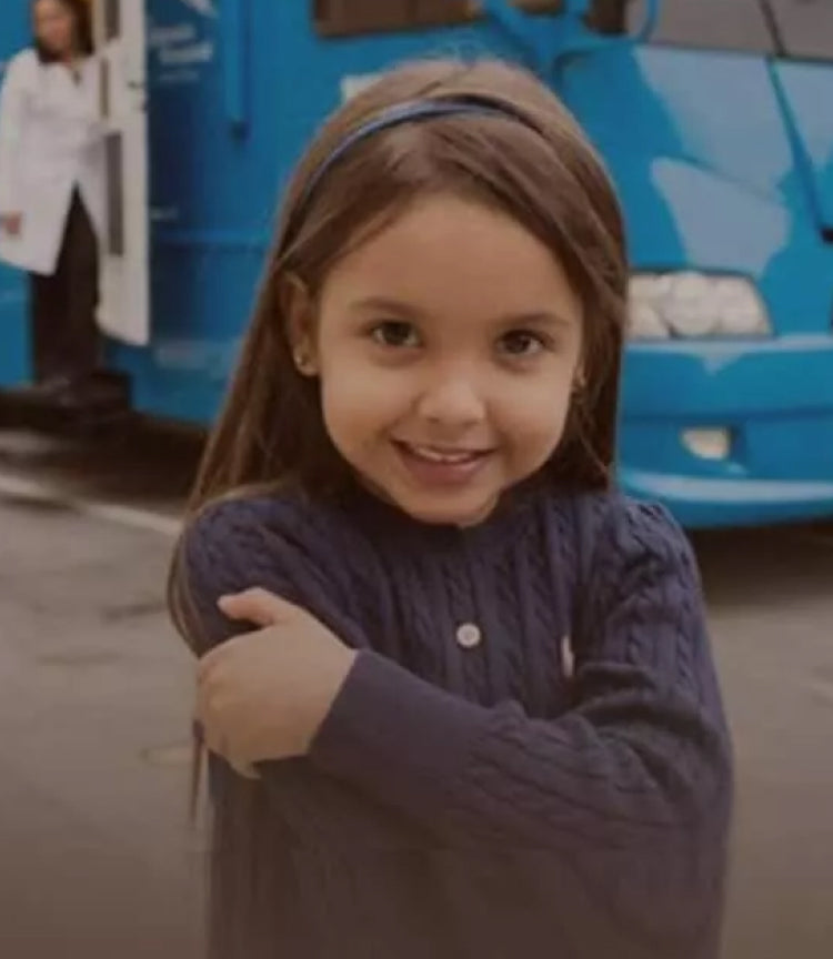 A little girl standing on the side of the road