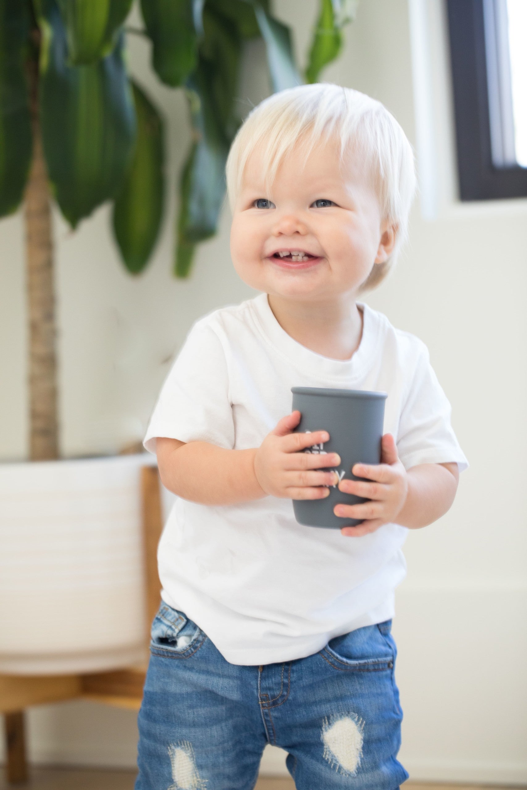 Sip Sip Hooray Happy Sippy Cup by Bella Tunno being held by a boy kid