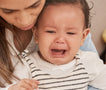 woman comforting crying baby in her lap