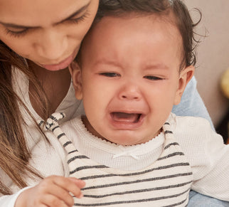 woman comforting crying baby in her lap