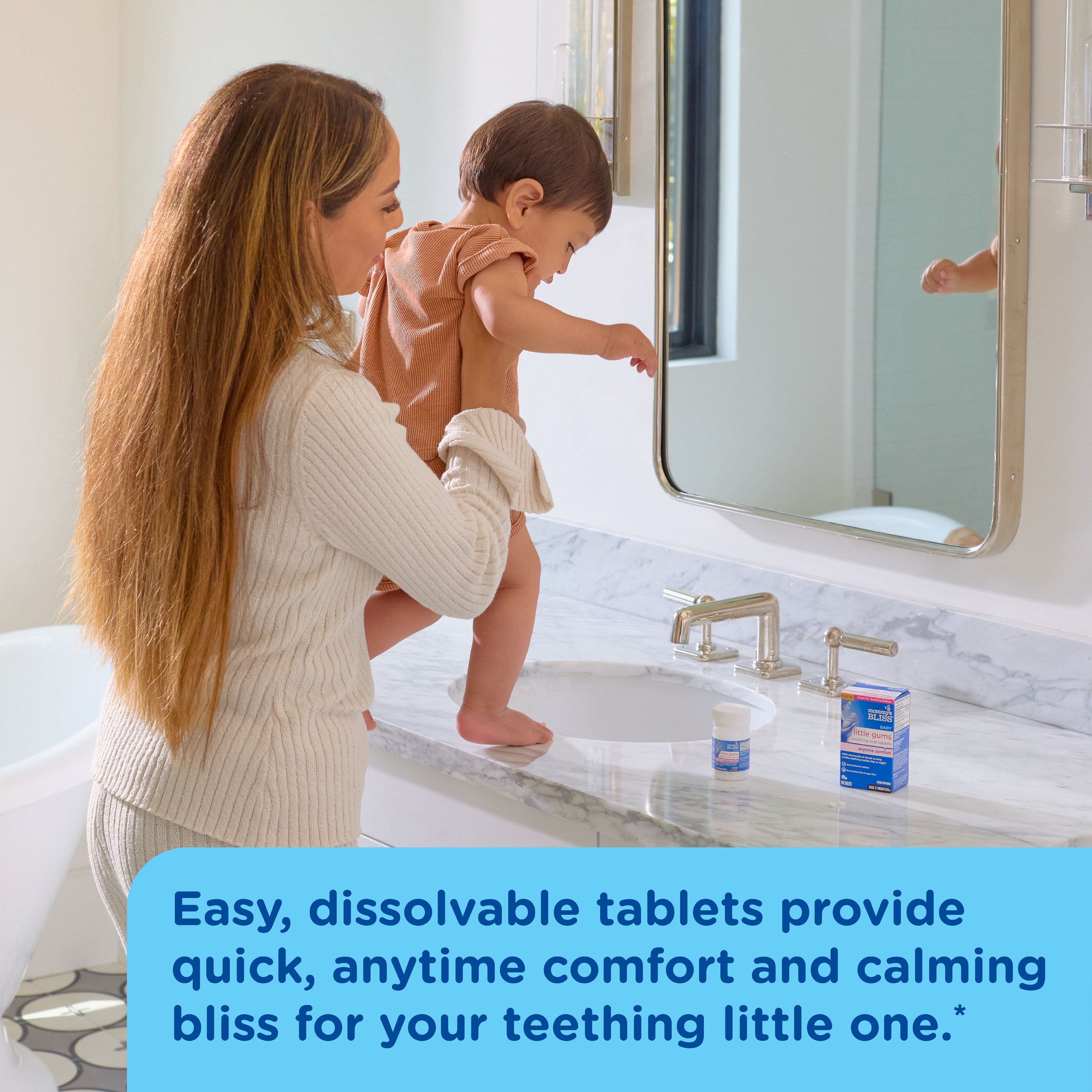 A mom holding her toddler at the bathroom kitchen sink with Mommy's Bliss soothing oral tablets on the counter